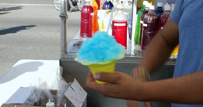 Salesperson sells scoops of refreshing homemade shaved ice cream with colorful rainbow syrup for little children in Los Angeles, California, 4K