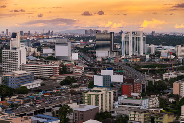 Aerial view of Bangkok city skyline and express way in golden yellow light sunset sky