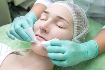 Facial cleansing by a beautician in a beauty salon