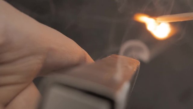 Match moves on matchbox and light the fire