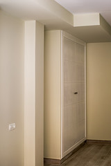 Empty modern room newly renovated with floating laminate flooring and newly painted wall