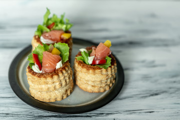 French cuisine, crunchy patties with lettuce and smoked salmon on a bright, rustic background