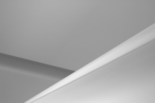 Refined abstract architecture or interior design photo of plastered ceiling. Minimalist geometric background with angular structure and copyspace for text placement.