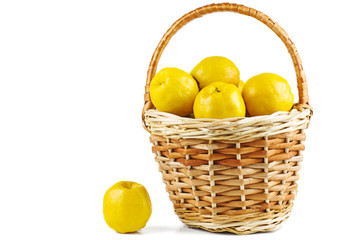 Maules quince (Chaenomeles japonica) in wicker basket isolated on white background