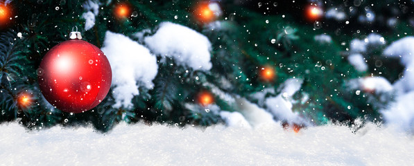 Red Ball Hanging At Fir Branches with snow, snowflakes and lanterns, festive greeting card background.