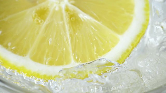 Lemon in water with ice, closeup, 4K
