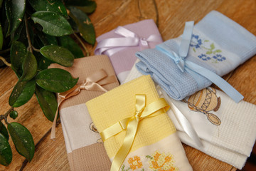 Beautiful napkin for celebrations. Different kitchen dish towel or napkin in various of colors on wooden table and home lianas in the background.