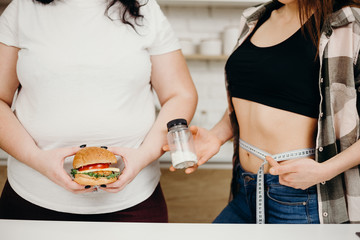 weight loss, fat burning, pharmacy,nutrition choices.overweight woman with tasty burger and fit...