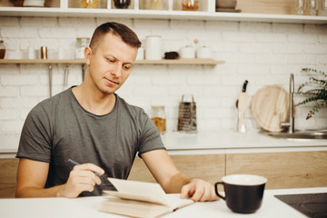 inspiration, deadline, day planning, lifestyle, early awake. man writing in diary drinking morning...