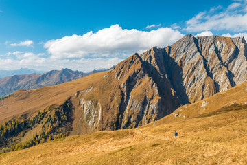 Trekker hiking in autumn alps with superb mountain plates in behind, Grossglockner area, Tyrol, Austria