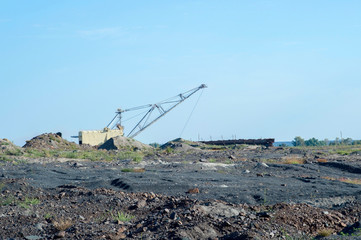 A huge excavator carries rock from the unloaded train from the mine. The concept of mining and...