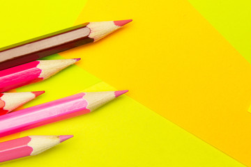 Colored pencils on the multi-colored paper background.Concept back to school. Geometric paper texture background. Template