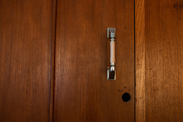 Cabinet wooden door handle with a hole waiting for fix it.