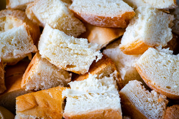 Slice of bread cut into small pieces. Closeup of food photo.