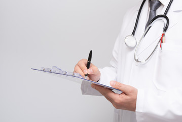 Close up of doctor's hands writing on medical chart.