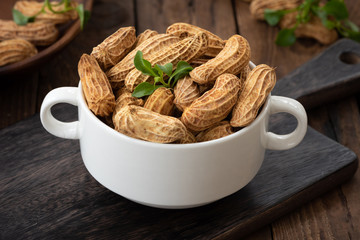 Raw peanuts in white bowl


