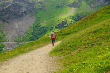 Fototapeta na wymiar Hiker traveling in Alps. Alpine peaks landskape background. Jungfrau, Bernese highland. Sport, tourism and hiking concept.