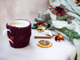 Golden stars, gift box, orange, cinnamon, cozy cup of coffee, christmas tree branch and decorations on light pink textured background. Christmas, new year, winter concept. Selected focus