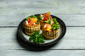 French cuisine, crunchy patties with lettuce and smoked salmon on a bright, rustic background