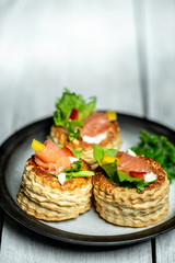 French cuisine, crunchy patties with lettuce and smoked salmon on a bright, rustic background