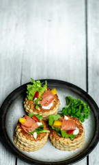 French cuisine, crunchy patties with lettuce and smoked salmon on a bright, rustic background