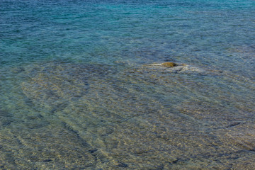 sea stone shallow bottom and blue transparent water surface background nature concept 