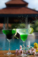 margarita cocktail on poolside bar and water splash