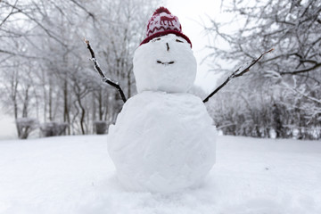 Obraz premium Winter mood: Small simplistict snowman in Christmas hat
