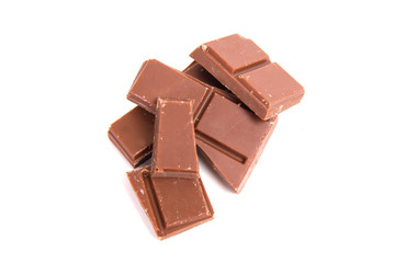 Milk chocolate pieces isolated on white background
