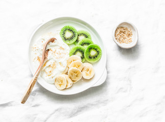 Healthy diet breakfast - greek yogurt with honey and fruit on a light background, top view. Copy...