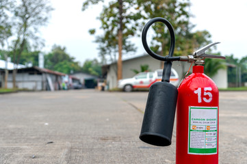 closeup red fire extinguisher with soft-focus and over light in the background