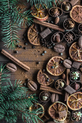 Fototapeta na wymiar Christmas sketch. Lots of chocolate and chocolates, cinnamon, orange dried slices and spruce twigs. Holiday Decor. Close-up.
