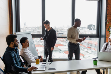 Collaboration and analysis by multiracial mixed race business people working in office