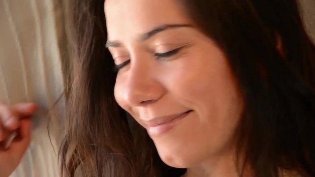 Giovane donna guarda dalla finestra in cerca del proprio uomo