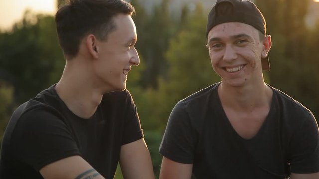 young best friends talking outdoors,sunset,sunlight background