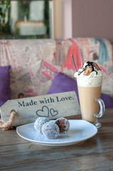 Chocolate balls on white plate and cafe latte with caramel chocolate on top