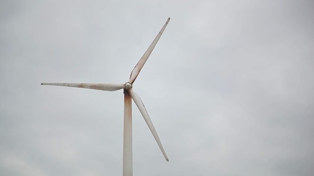 rusty wind generator closeup, grey sky bg