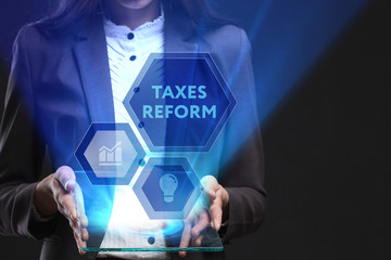 The concept of business, technology, the Internet and the network. A young entrepreneur working on a virtual screen of the future and sees the inscription: taxes reform