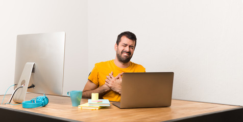 Man working with laptot in a office having a pain in the heart