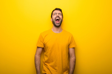 Man on isolated vibrant yellow color shouting to the front with mouth wide open