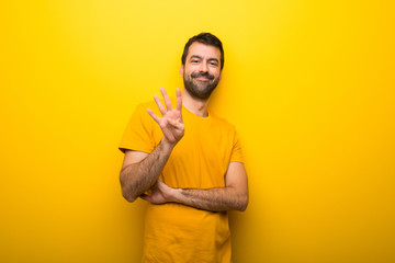 Man on isolated vibrant yellow color happy and counting four with fingers