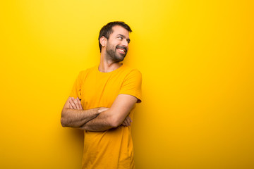 Man on isolated vibrant yellow color looking over the shoulder with a smile