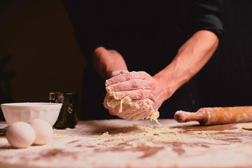hands kneading dough on wooden table