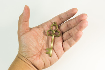 The vintage gold key in hand close up image.