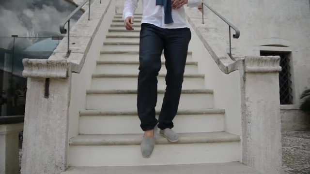 Giovane uomo scende le scale di un'antica masseria