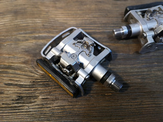 Pair of mountain bike contact pedal isolated on wood background. Close up.