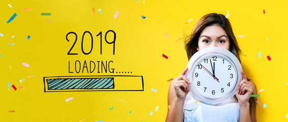 Loading new year 2019 with young woman holding a clock showing nearly 12