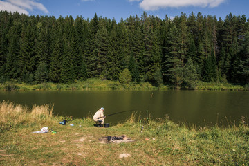 Russian fisherman fishes by lake