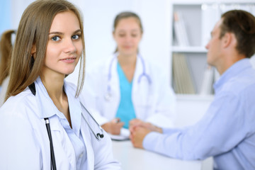 Fototapeta premium Happy doctor woman with medical staff at the background in hospital office