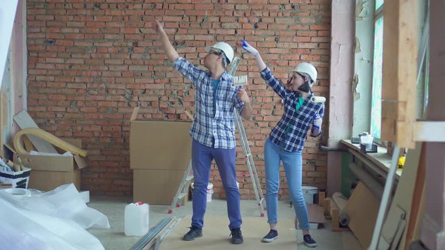 cheerful builders are dancing during the repair